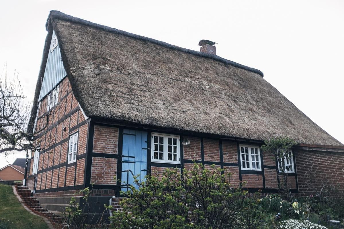 Fachwerkhaus mit Reetdach, schräg von der Ecke.