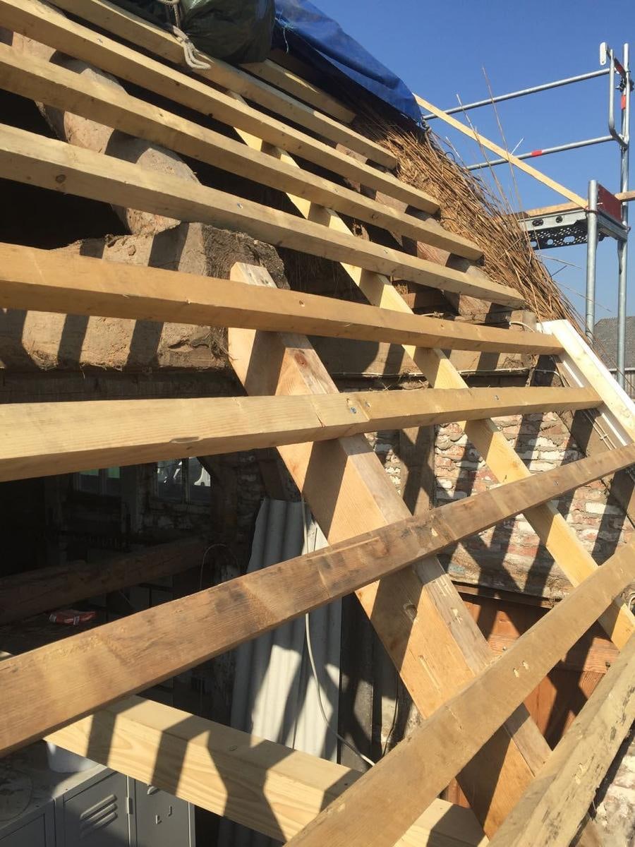 Holzlattung schräg von unten, daneben Gerüst.