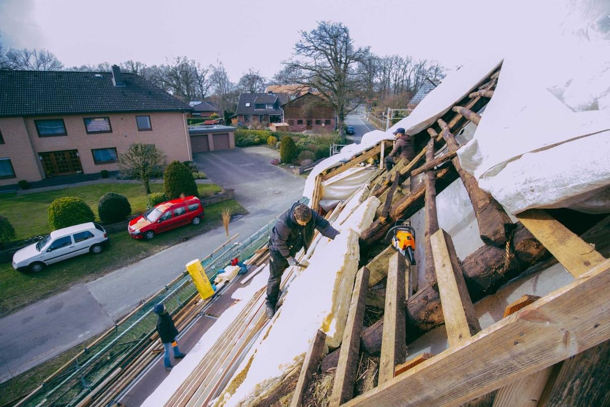 Schräg von oben: alte und neue Dachteile, unten Häuser und Autos.